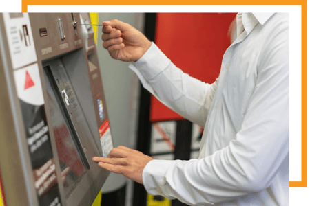 Utilizador final a inserir um bilhete numa máquina de venda automática