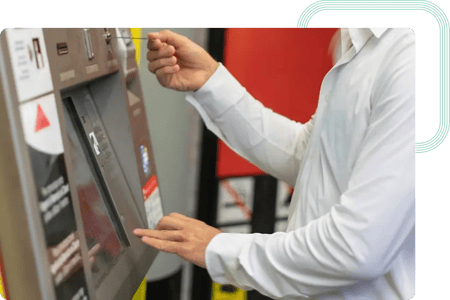 Utilizador final a inserir um bilhete numa máquina de venda automática